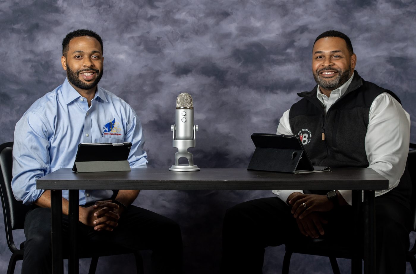 B.O.S.S. hosts recording an episode of the H.O.T. Takes series at the studio table with a microphone